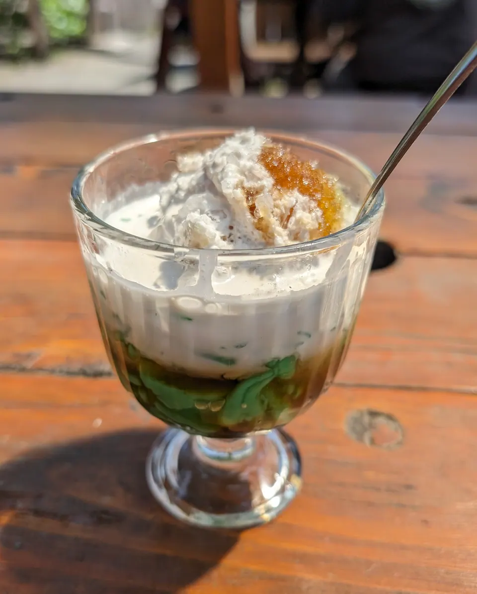 Segelas es cendol dengan santan dan gula aren di sebuah warung