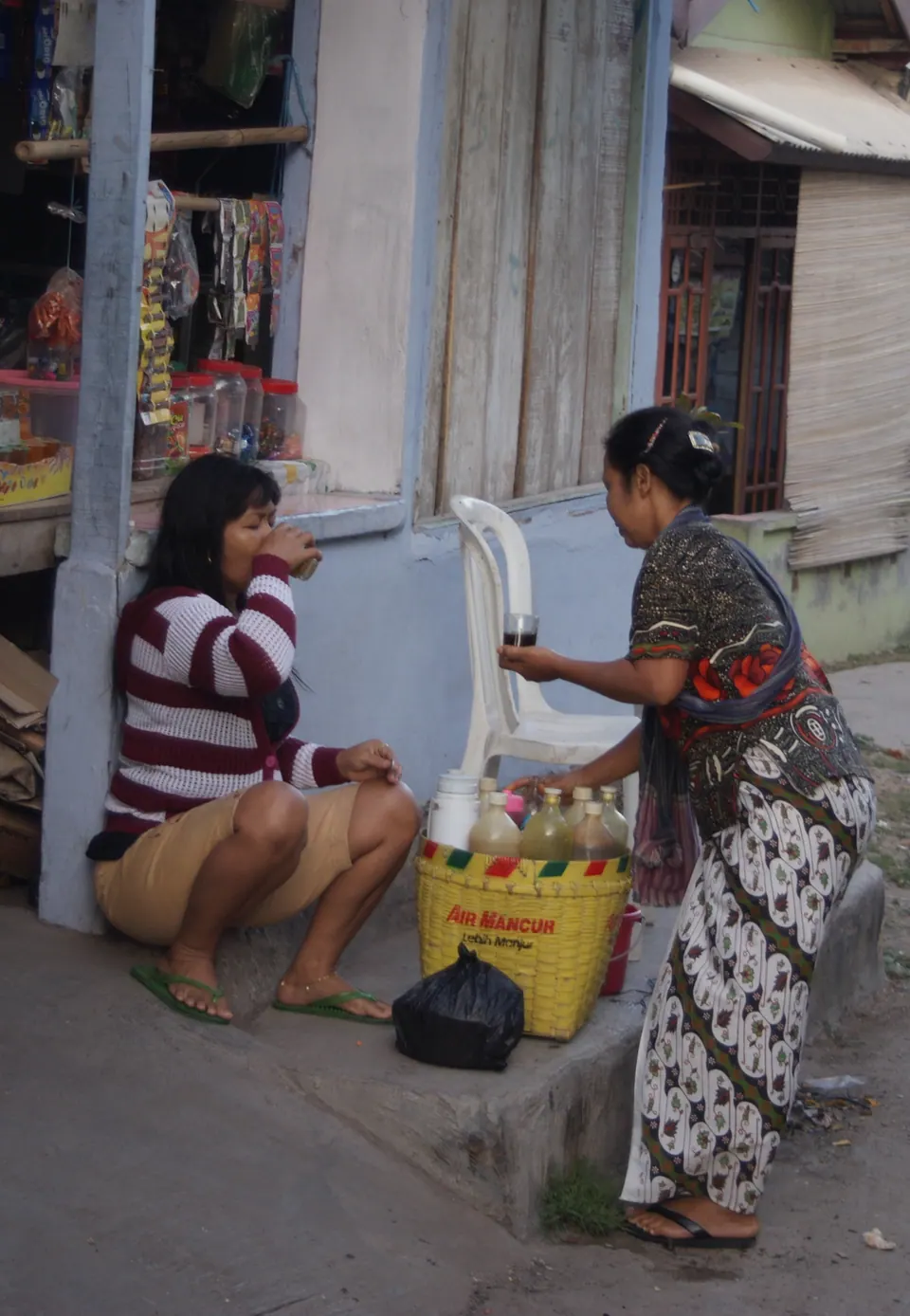Seorang pembeli meminum jamu gendong dari gelas di Bandar Lampung