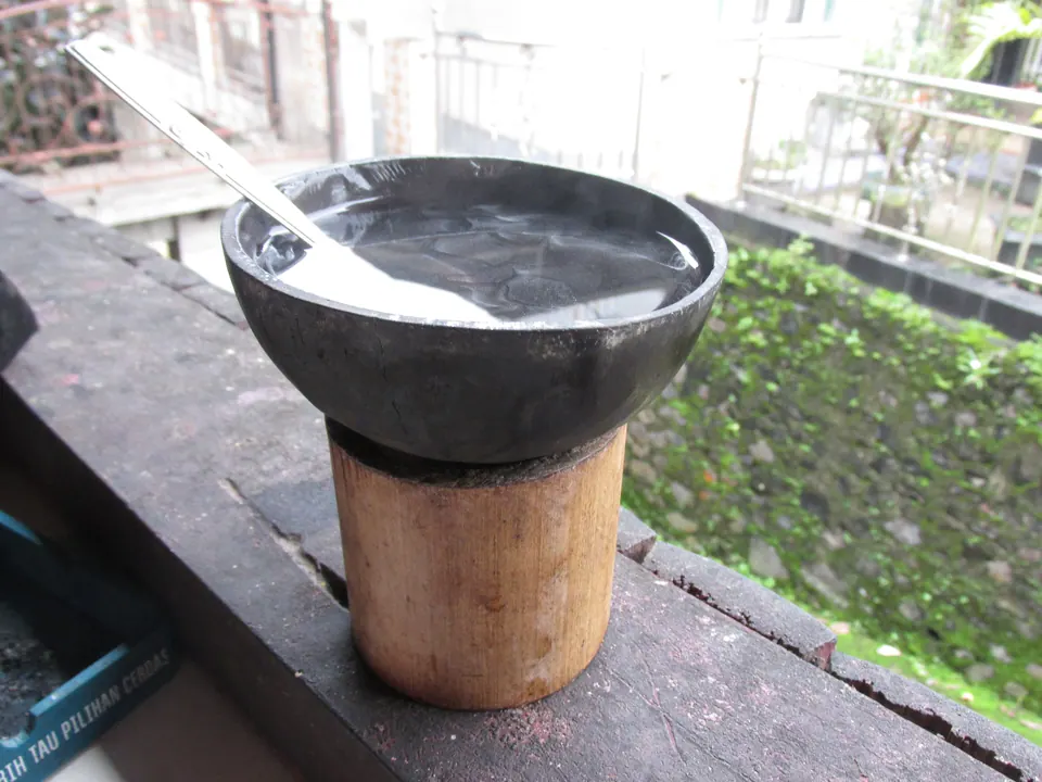Kawa daun disajikan dalam tempurung kelapa yang ditumpangkan pada potongan bambu, khas Batusangkar