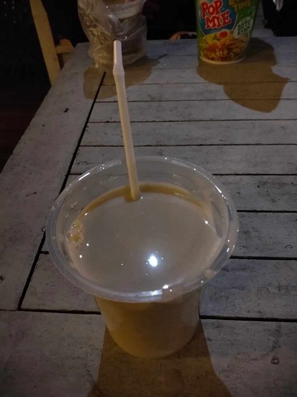 Segelas STMJ hangat berbuih di sebuah warung malam di Batu, Malang