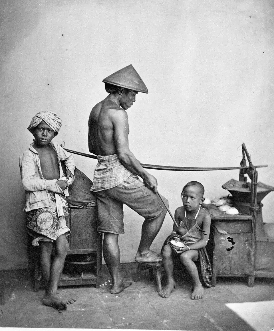 Foto hitam putih sekitar 1870 karya Isidore van Kinsbergen: penjual bandrek keliling di Batavia dengan pikulan