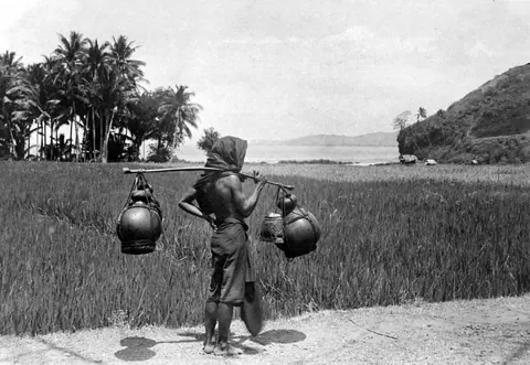Foto arsip Tropenmuseum awal abad ke-20: penjual tuak di Bali dengan wadah-wadahnya