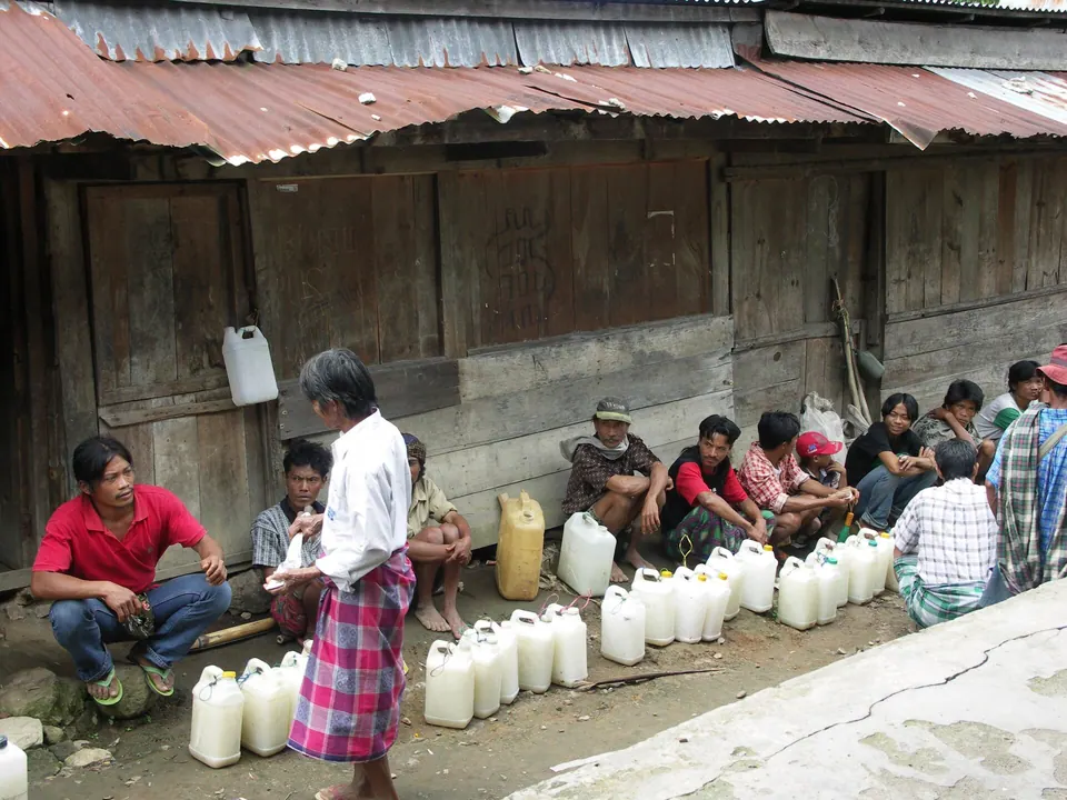 Penjual tuak di pasar Bittuang, Tana Toraja, dengan wadah-wadah tuak berjajar