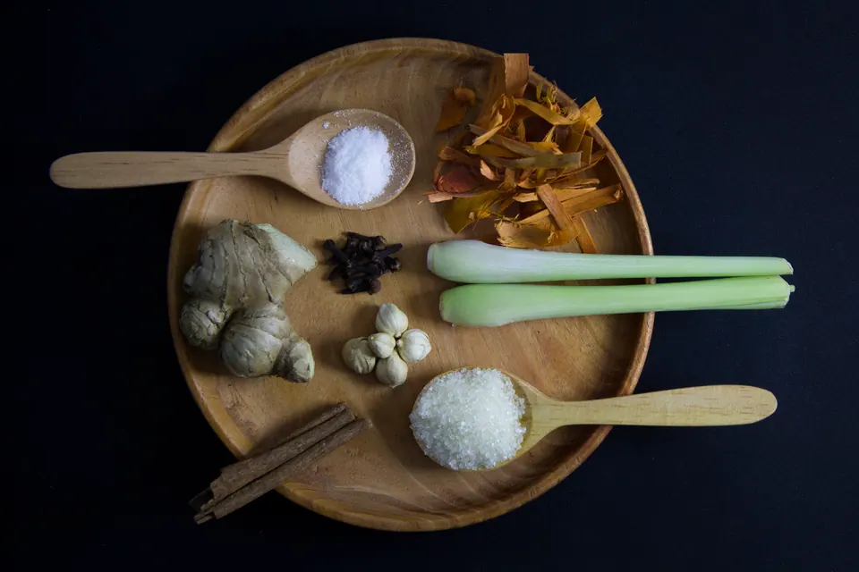 Bahan wedang secang: serutan kayu secang merah, jahe, kayu manis, kapulaga, dan cengkih di atas meja